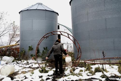 farmer Kevin Stuedemann carries empty buckets after feeding whey to his pigs on Derrydale Farm in Belle Plaine, Minnesota, U.S.