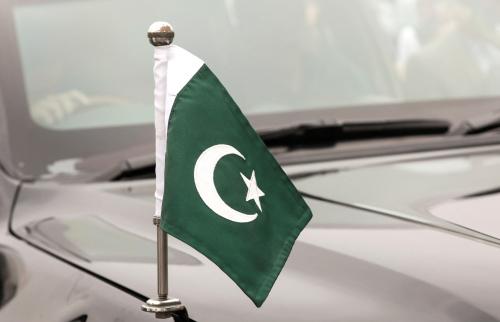 A Pakistani flag flies from the hood of a car during Independence Day celebrations