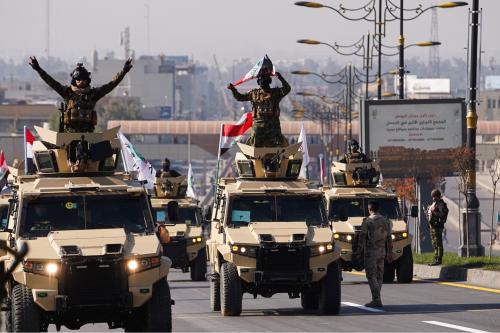 Members of Iraq's Popular Mobilization Forces ride military vehicles during a military parade in celebration of "Victory Day" marking the seventh anniversary of the defeat of Islamic State militants and the liberation of Iraqi territories, in Mosul, Iraq.